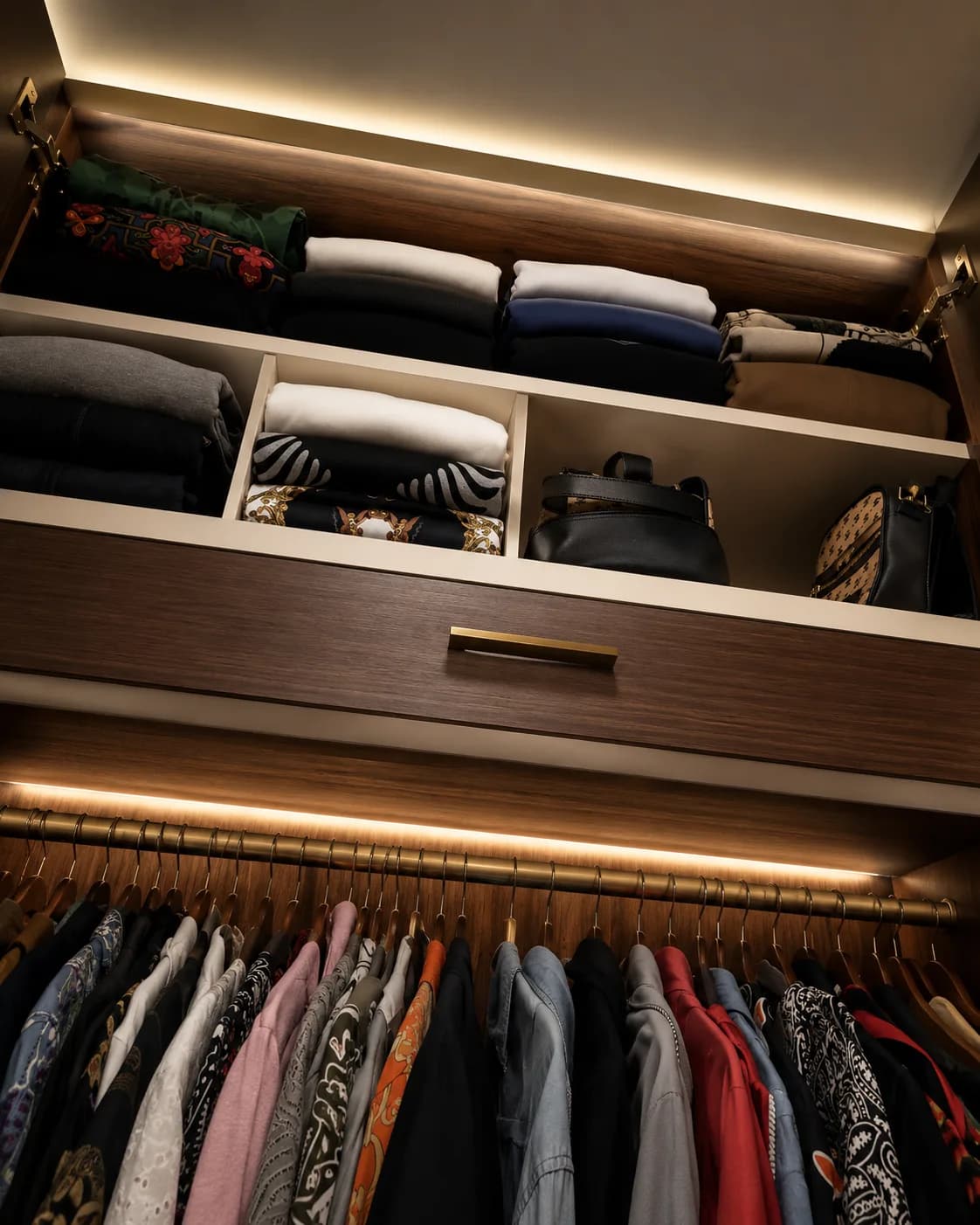 Closet em madeira escura com gaveta de roupas dobradas, nichos de bolsas e cabideiro iluminado, Silvana Organizer