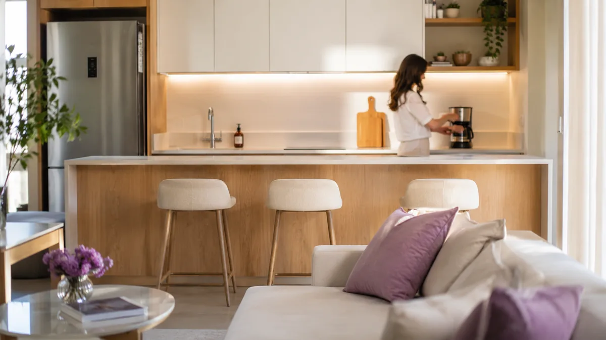 Cozinha americana integrada com sala em apartamento de São Paulo com bancada livre e armários organizados por zonas
